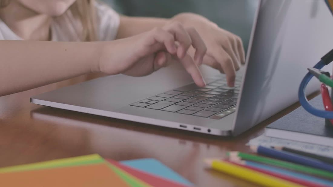 Learner typing on a laptop while completing an online course