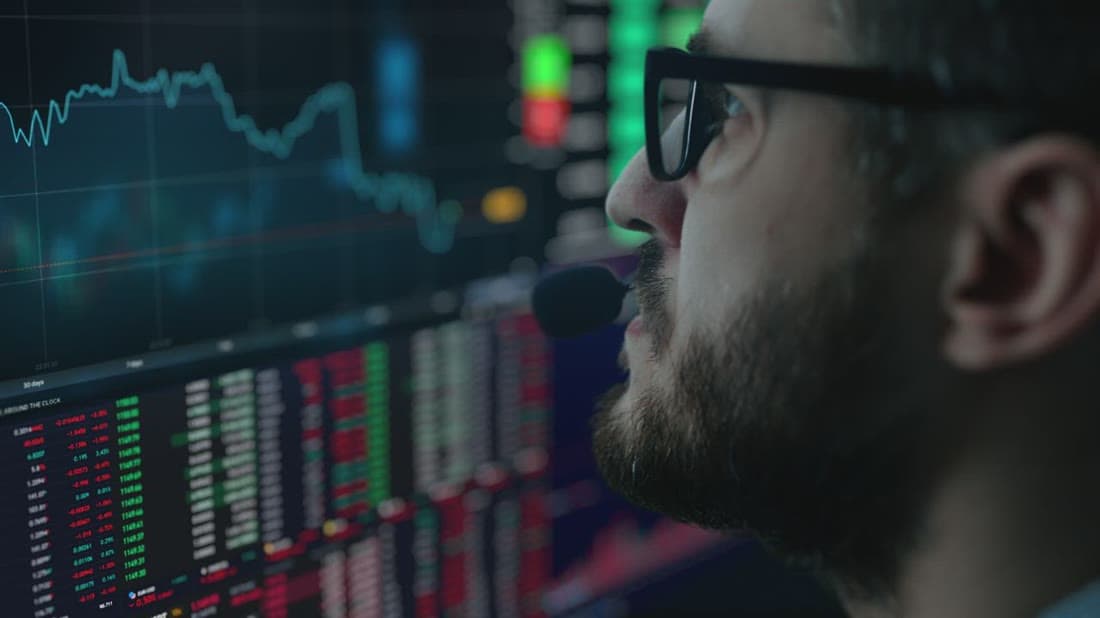 Trading desk analyst monitoring Forex charts across multiple screens