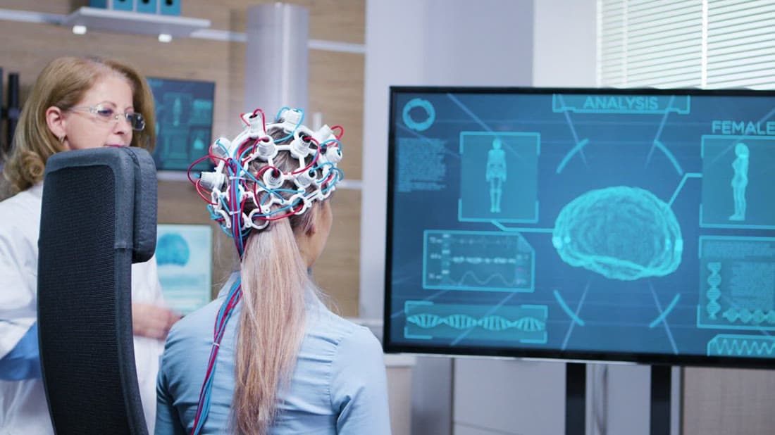 Doctor reviewing a digital brain scan with a patient on a large screen