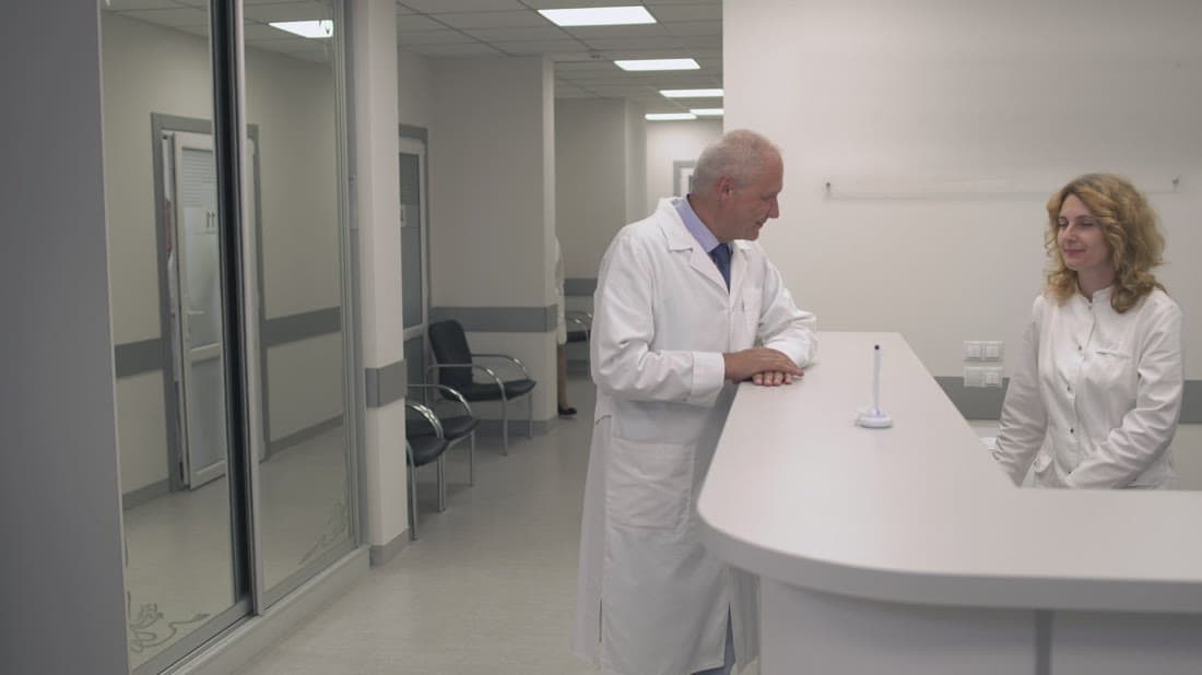 Hospital reception staff assisting a patient at a modern clinic