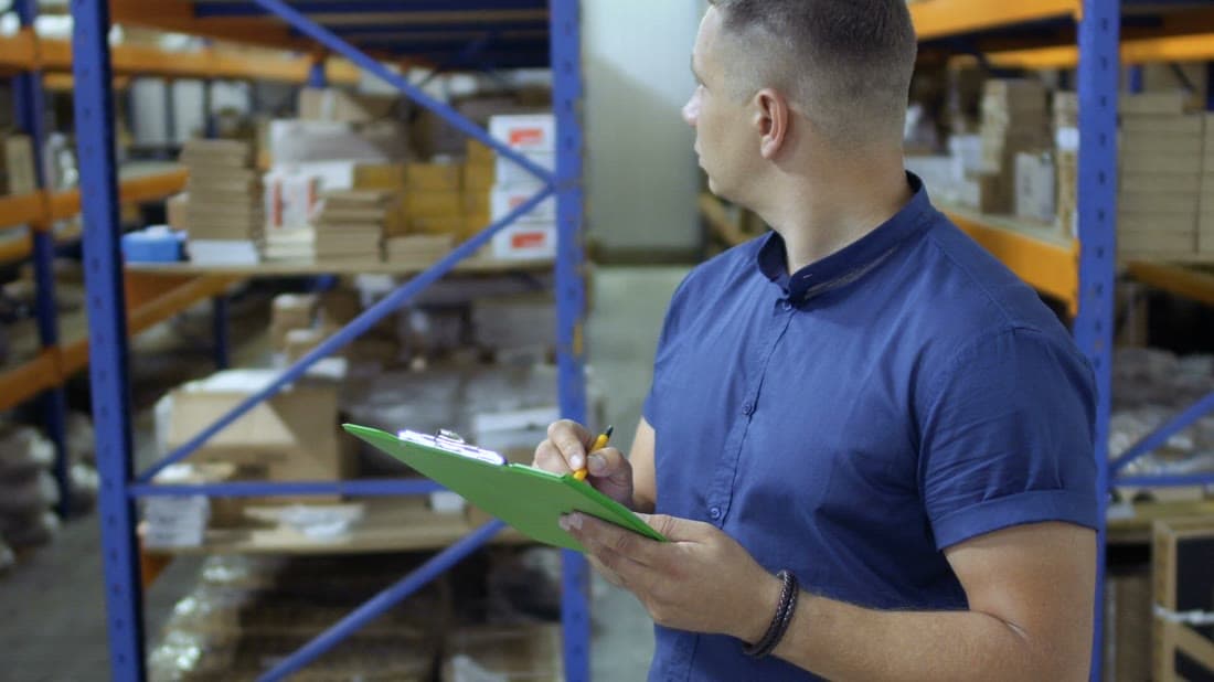 Warehouse worker checking inventory with a digital tablet
