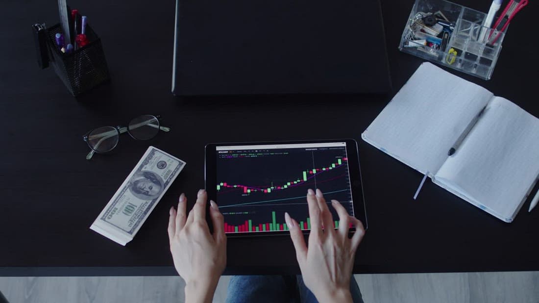 Investor reviewing stock charts and portfolio performance on a tablet