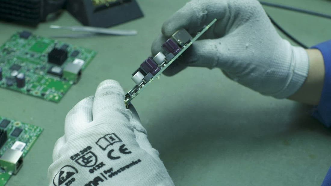 Technician performing a quality check on an electronic circuit board